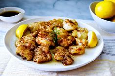 a white plate topped with chicken and lemons