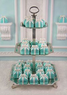 two tiered trays with blue and white decorated cookies on them, each holding a bow