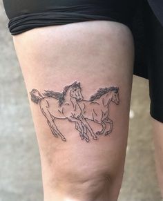 a woman with a tattoo on her leg that has two horses running behind it,