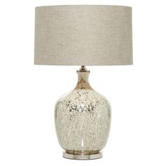 a glass table lamp with a beige shade