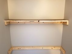 two wooden shelves in the corner of a room