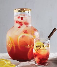 a pitcher filled with liquid next to two glasses