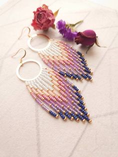 "These handwoven earrings are made with white, pink, purple, and gold beads in a beautiful soft gradient. They are made to order so please allow an extra 1-3 days for me to complete them. Beads: Handwoven with the highest quality Miyuki Rocaille beads. These round glass beads are precisely engineered to ensure the highest degree of consistency in shape and size. Earwires: Earwires are your choice of gold-plated or 14k gold-filled* and are safe for most sensitive ears. Dimensions: The earrings ha Unique Beaded Earrings, Bead Loom Earrings, Purple Fringe, Handwoven Earrings, Soft Gradient, Iris Purple, Beautiful Beaded Earring, Seed Bead Jewelry Patterns, Homemade Earrings