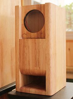 a small wooden object sitting on top of a table next to a window sill