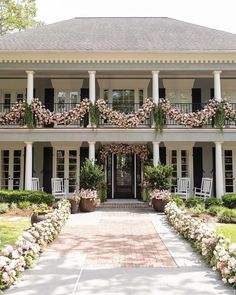 a large white house with lots of flowers on the front