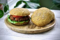 two hamburgers sitting on top of a wooden plate