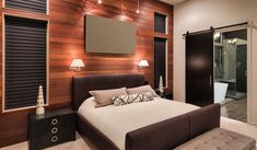 a bedroom with a large bed and wooden walls