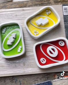 three bowls with different designs on them sitting next to each other in front of a piece of wood