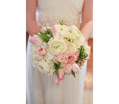 a bride holding a bouquet of white and pink flowers