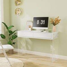 a white desk with a computer on top of it next to a potted plant