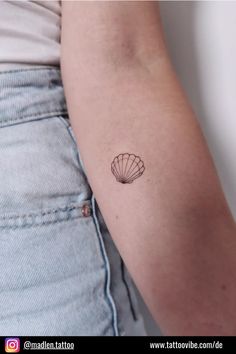 a small shell tattoo on the left arm