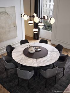 an image of a table with chairs and lights on it in the middle of a room