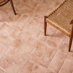 a chair sitting on top of a tile floor next to a wooden table and chairs