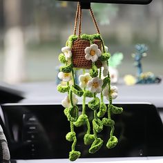 a crocheted flower hanging from the dashboard of a car