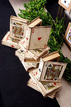 four playing cards are stacked on top of each other in front of some greenery