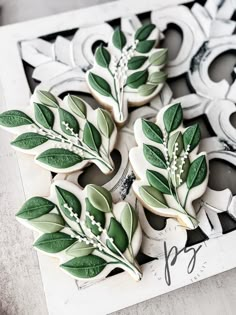 cookies decorated with green leaves and white flowers