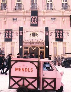 a pink truck parked in front of a building