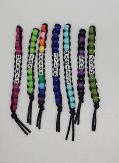 six different colored lanyards with name tags attached to each one, all lined up in the same row