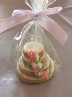 some cookies in a clear bag with pink flowers on them and a ribbon tied around the top