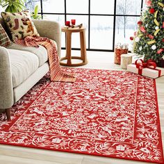 a living room with a christmas tree and red rug