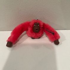 a red stuffed animal sitting on top of a white table