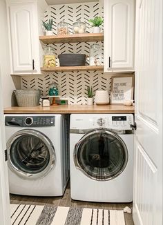 a washer and dryer in a small room with white cabinets on the wall