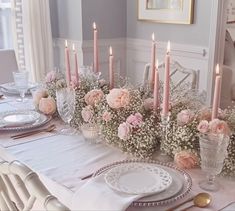 the table is set with pink flowers and candles