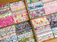 four boxes filled with different types of fabric in each box and one is open to show the