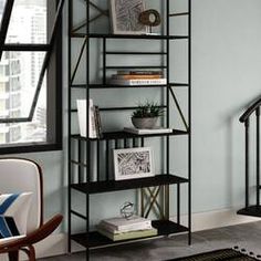 a living room with blue walls and black shelving unit in the corner next to a chair