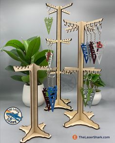 three metal jewelry stands with plants in the middle and one standing on it's side