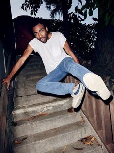 a man in white shirt and jeans jumping on stairs