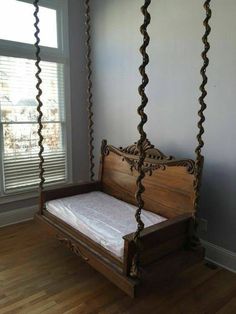 a wooden swing bed in the corner of a room