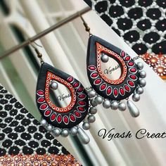 the earrings are decorated with red and black beads