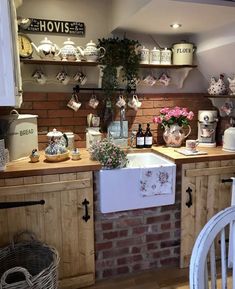 a kitchen filled with lots of wooden cabinets and counter top space next to a brick wall