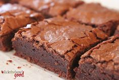 chocolate brownies are sitting on a white surface