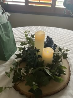 some candles are sitting on a table with greenery