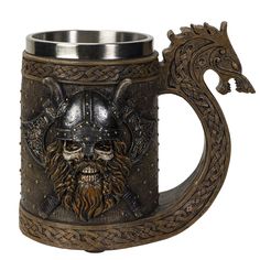 a metal beer mug with a skull and helmet on the inside is decorated with an intricate dragon handle