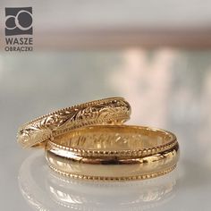 two gold wedding rings sitting on top of a table