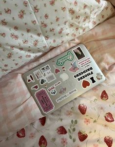 an unopened package is laying on a bed with strawberrys and pink sheets