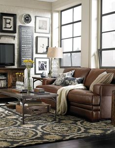 a living room filled with lots of furniture and decor on top of a hard wood floor