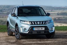 a blue suv parked on top of a dirt road