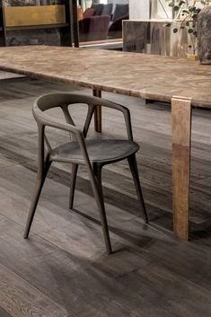 a wooden table with two chairs and a vase on the end, in front of it