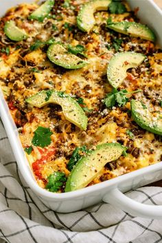 a casserole dish with zucchini, cheese and other vegetables in it