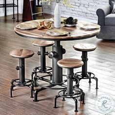 a kitchen table with four stools and plates on the counter top in front of a brick wall