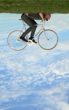 a man riding a bike in the sky with clouds behind him and an arabic quote below