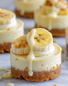 banana cheesecakes are topped with whipped cream and drizzled with bananas