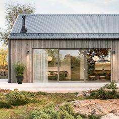 a wooden building with glass doors on the front and side windows that look out onto an outdoor patio