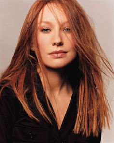 a woman with long red hair posing for a photo