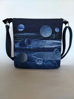 an image of a purse with planets on the front and back side, sitting on a table