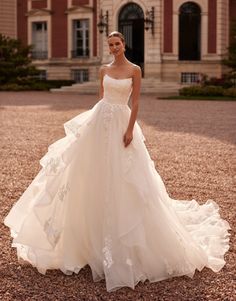 a woman standing in front of a building wearing a wedding dress